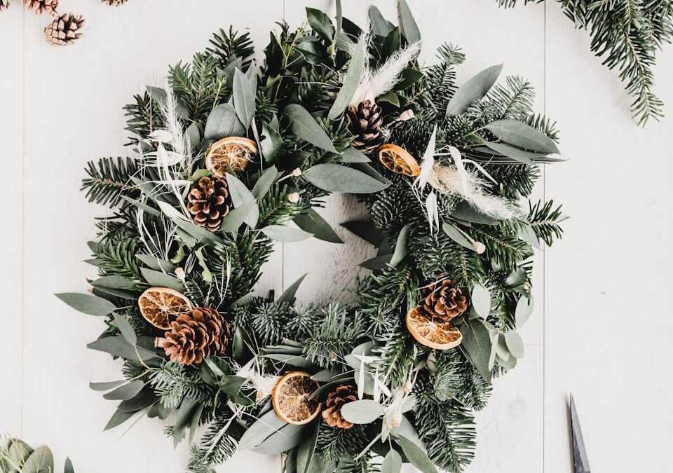 a wreath with pine cones and evergreen leaves